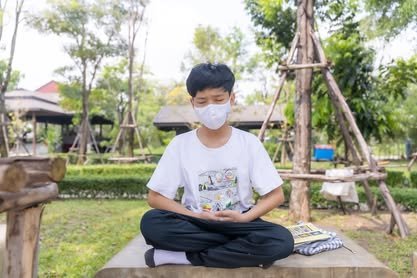 ผู้ปฏิบัติธรรมนั่งสมาธิในสวนของวัด